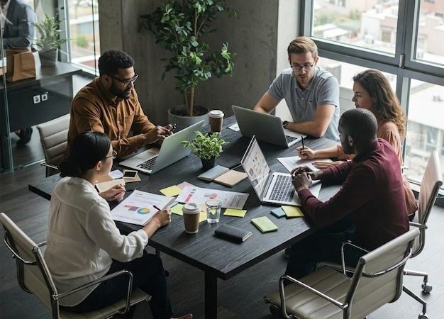 Fünf Personen besprechen Unterlagen und Laptops an einem Bürotisch