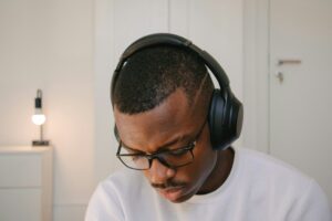 Mann mit Brille und Kopfhörern konzentriert bei der Arbeit